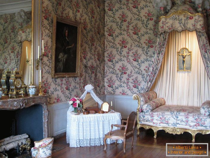 Šarena dekoracija zidova je u saglasnosti sa tapaciranjem sofe i nadstrešnicom nad njom. Barokni salon sa velikim kaminom je odlična ideja za seosku kuću.