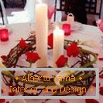 Dekoracija stola sa svećama i cvetnim laticama