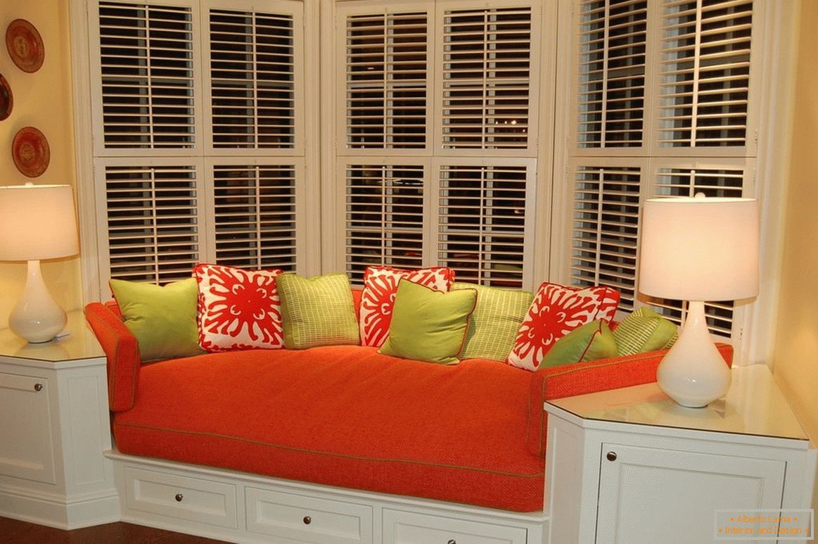 Crveni sofa sa obojenim jastucima