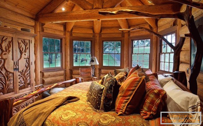 Jedna od spavaćih soba u kući blizu jezera napravljena je u stilu ruralne zemlje. Drvena dekoracija. Masivni elementi namještaja i dekora odabrani su u najboljim tradicijama stila.