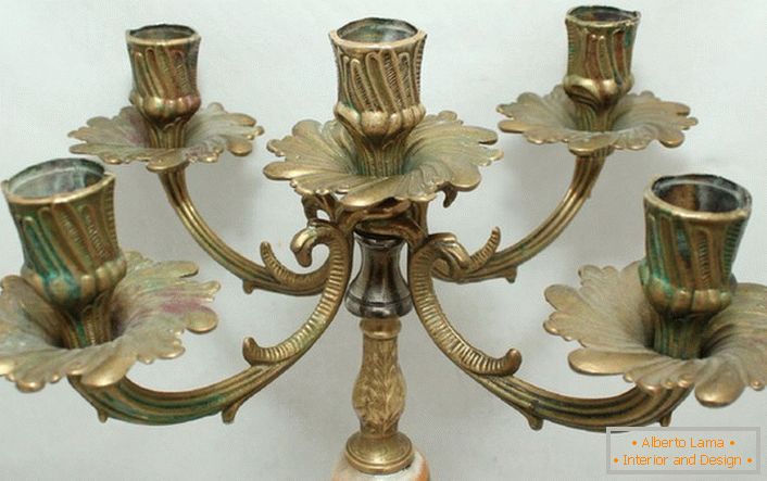 Moderan candelabrum od mesinga sa cvetnim motivima skladno je napisan u unutrašnjosti u stilu zemlje.