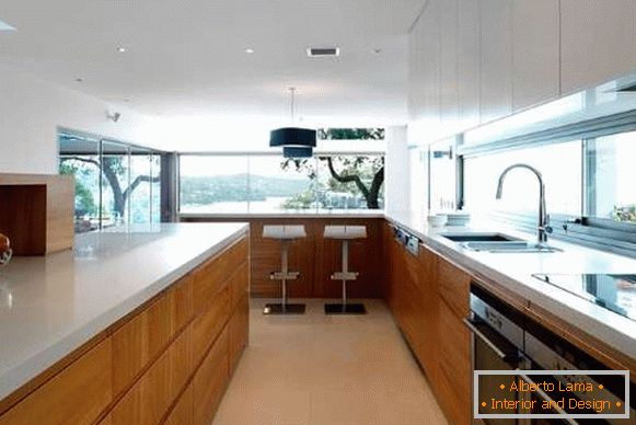 Bijela sa braon modernim kuhinjskim enterijerom sa prozorom u privatnoj kući