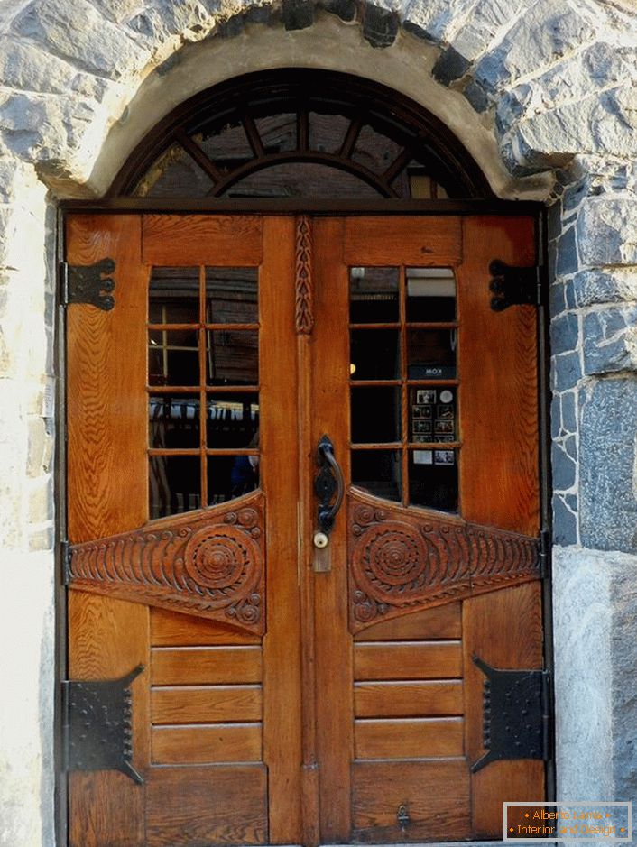 Vrata u stilu Art Nouveau ukrašavaju ulazna vrata jedne seoske kuće sa fasadom od prirodnog kamena. 