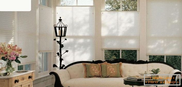 Moderne jednobojne, zračne zavjese-pleated ne preopterećuju prefinjenu atmosferu u dnevnoj sobi stare kuće. 