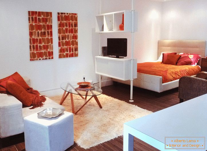 Unutrašnjost belog studio apartmana sa narančastim akcentima