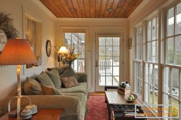 Glazirana veranda sa velikom kaučom i lampe