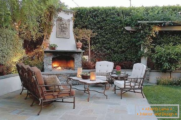 Izrada malog dvorišta privatne kuće - fotografija rekreacionog prostora с камином печью