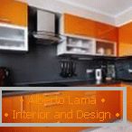 Plavi crni predpasnik u narandžastoj kuhinji