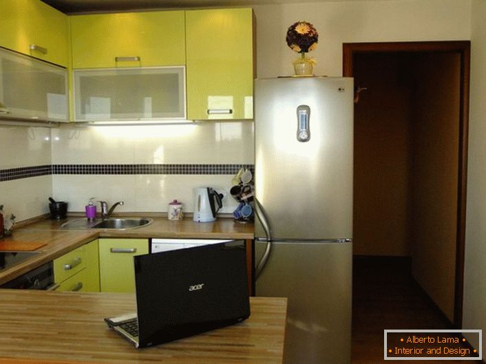 Elegantna kuhinja površine 12 kvadratnih metara nežne boje maslina. Prostor kuhinje je organizovan na praktičan i funkcionalan način.