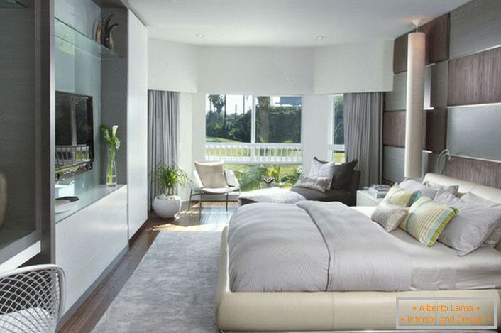 Mekani, rasuti krevet u spavaćoj sobi u modernom stilu. Nameštaj s sjajnom površinom dobro se uklapa sa ukupnim sastavom enterijera.