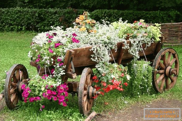 Kao posuđe za kreiranje cvjetnog ležaja korištena je stara, obnovljena kolica. Interesantno rešenje za dekor seoskog dvorišta. 