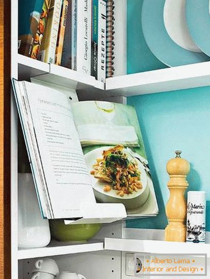 Knjige i posuđe u maloj kuhinji u tirkiznoj boji