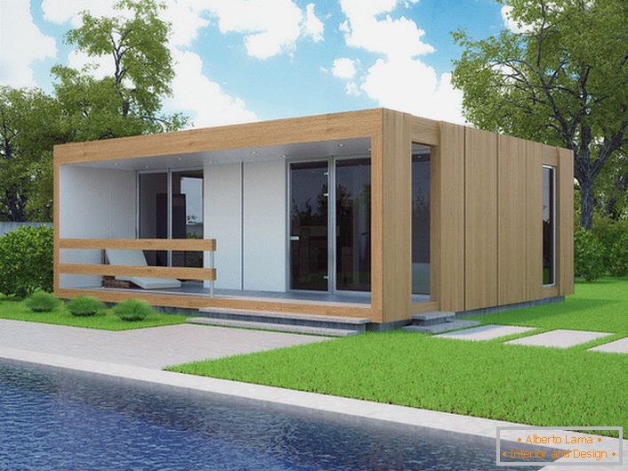 Mala modularna kuća sa bazenom u dvorištu. Stilski dizajn kuće koja se gradi brzo izgleda organski na pozadini kratkotrajnog travnjaka.