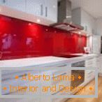 Bijeli namještaj i crvena bočica u unutrašnjosti kuhinje