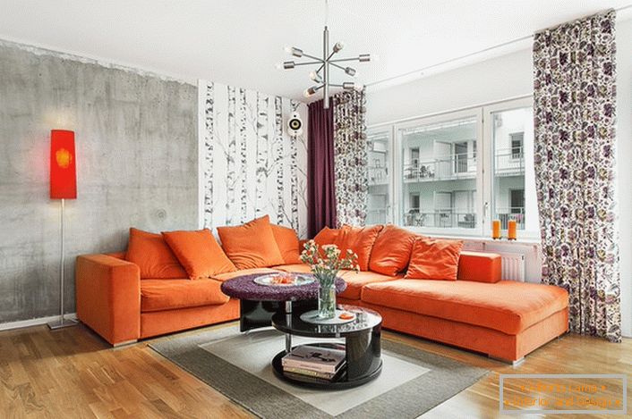 Skandinavski stil je inherentan u upotrebi toplih boja u dizajnu enterijera. Meki narandžasti sofe organski gleda na pozadinu zidova hladno sive boje.