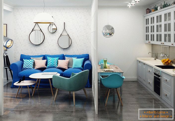 Tamno plava kauč je u kontrastu sa lakom završnom obradom. Primer uspješnog dizajna malog jednosobnog stana.