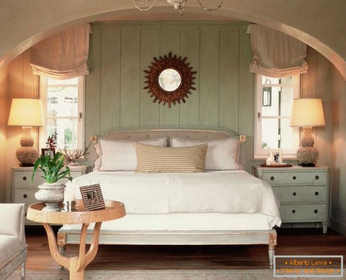 Obiteljska spavaća soba u stilu države. Toplinu kuće, što je više moguće, naglašava meki, volumetrički krevet, prekriven jastucima.