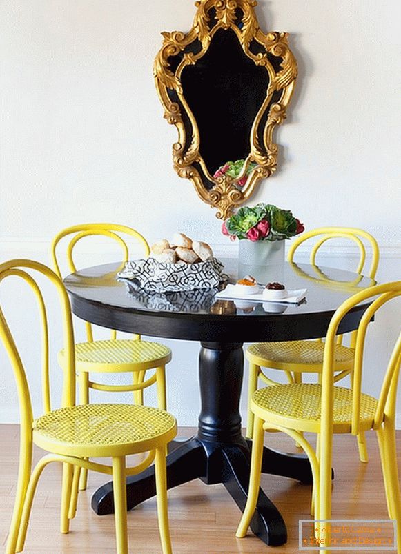 Svetlo žute stolice i crni stol za ručavanje