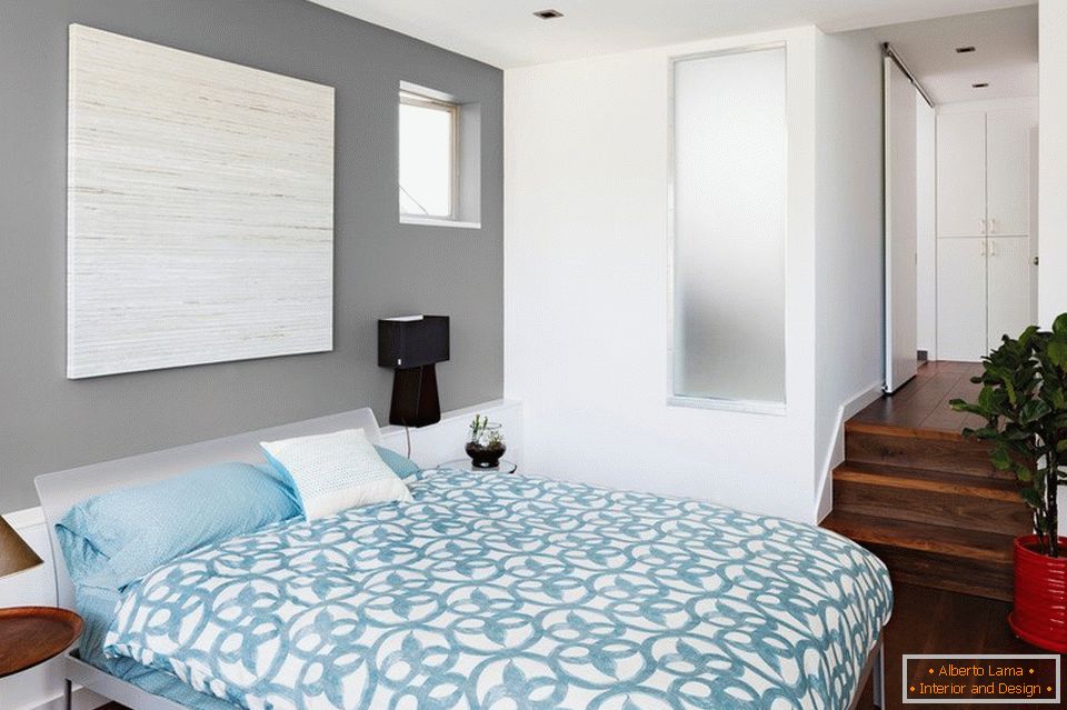 Plava posteljina i sivi zidovi u spavaćoj sobi