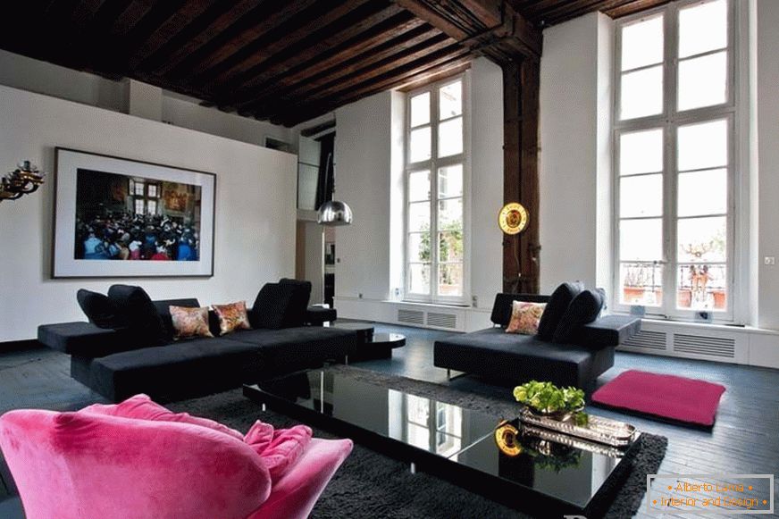 Crne sofe i ružičasta fotelja u sobi