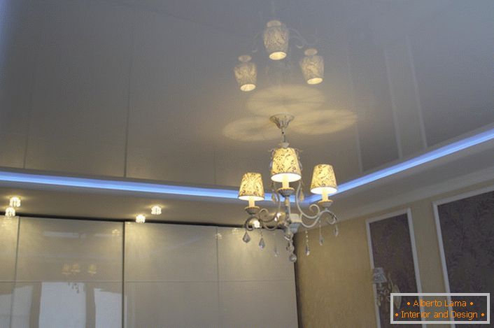 Neonska traka, koja deli stubove stropa, - neobično i spektakularno osvetljenje sobe.