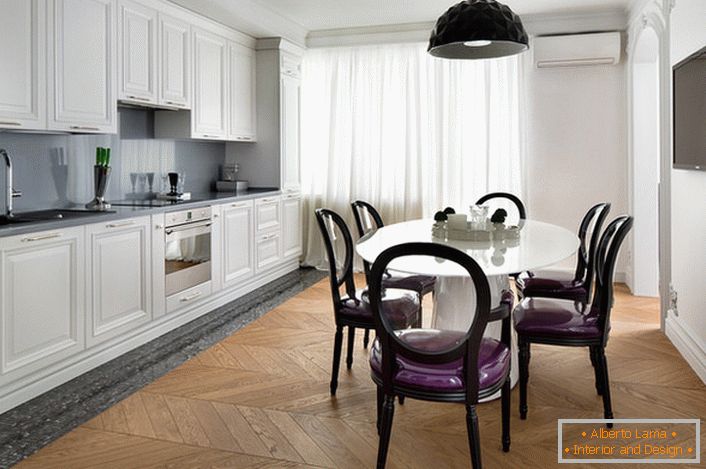 Bijela unutrašnja kuhinja sa akcentima tamno sive boje u eklektičnom stilu. Zanimljive stolice sa prozirnim leđima i ljubičastim mekim tapacirungom.